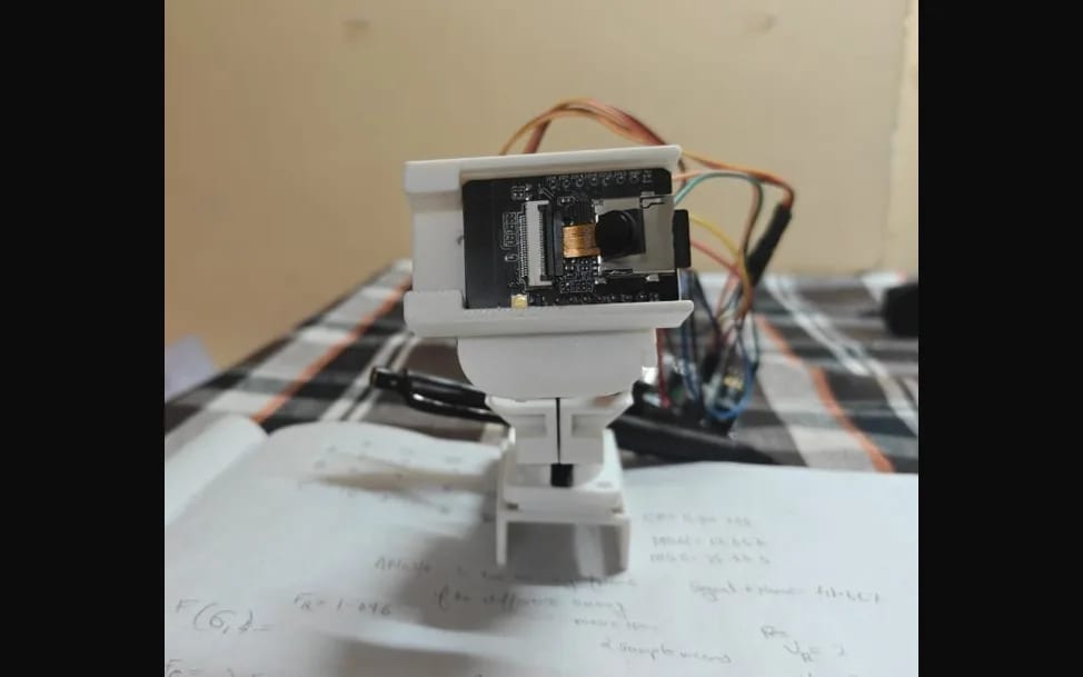 Netra — The build as it actually stands: camera, servos and a printed housing on the bench.